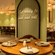 Round table seating arrangement beneath a decorative green arch wall with wooden chairs at OJ Japanese Restaurant, Featherlite Evoma Hotel.