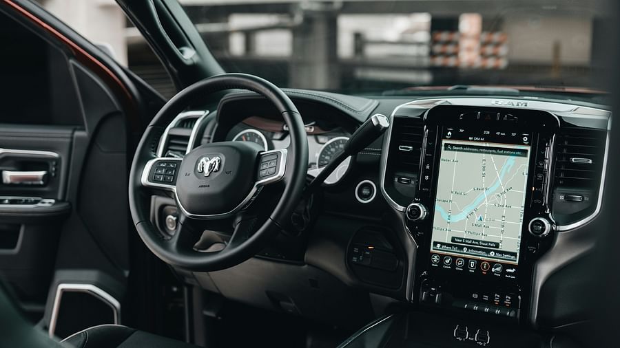 An overview of the interior of a car with steering wheel, maps and a dashboard in view