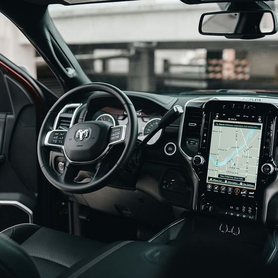 An overview of the interior of a car with steering wheel, maps and a dashboard in view