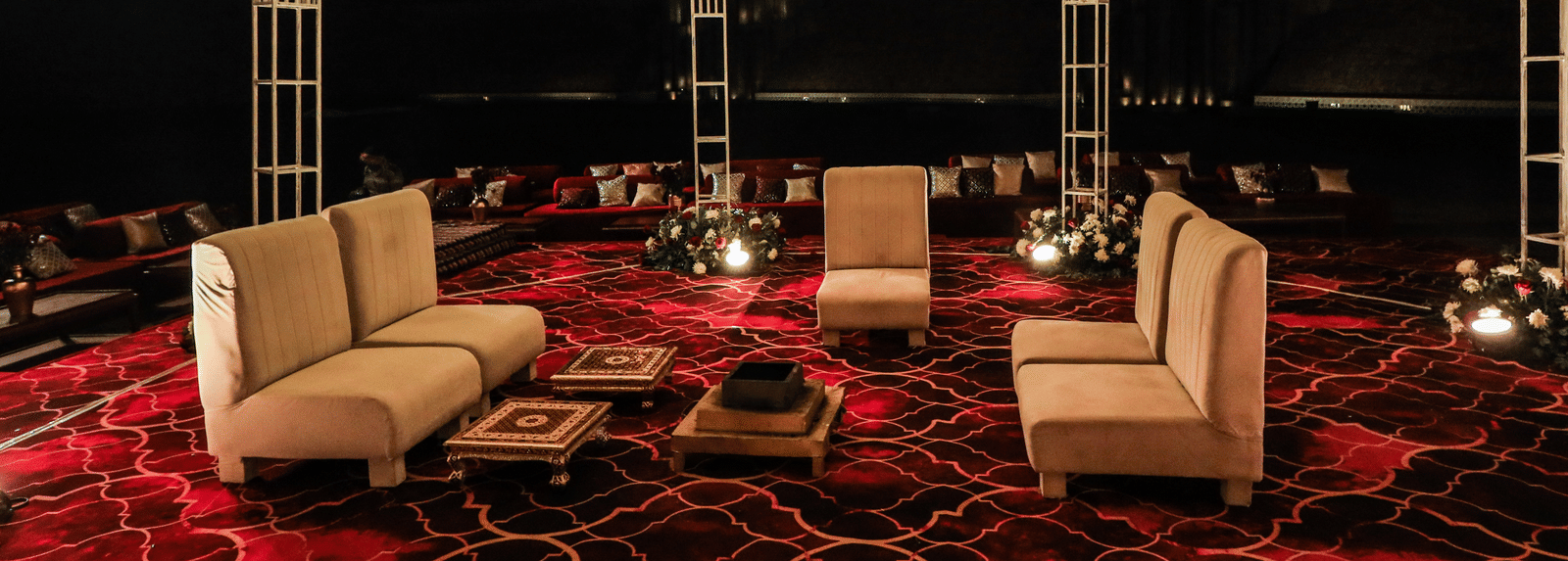 A seating area under a floral overhead installation with chairs and tables at Ananta Spa and Resort, Jaipur