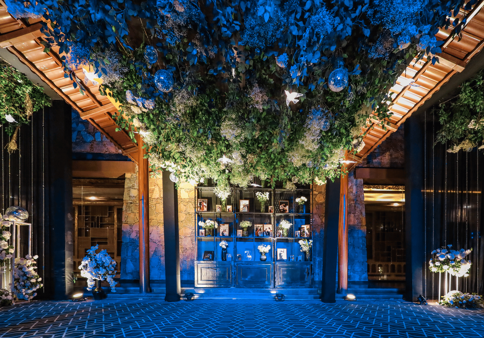 The lavish entrance area at Ananta Spa & Resort, Jaipur, features a dense, illuminated canopy of white flowers and foliage overhead.