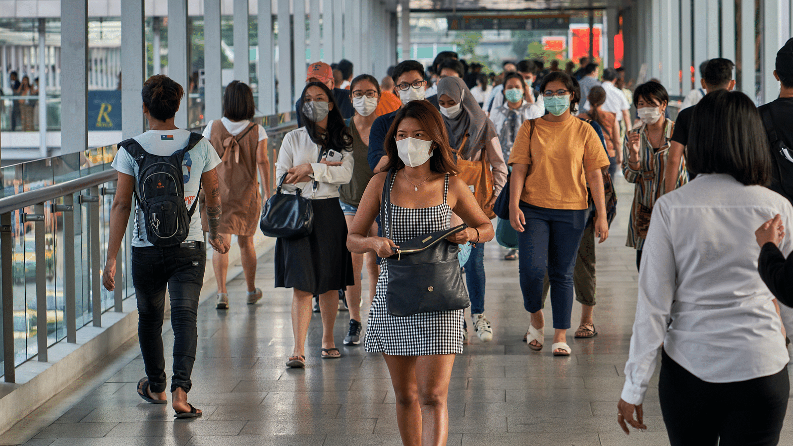 An overview of many people walking at a train terminal during daytime.