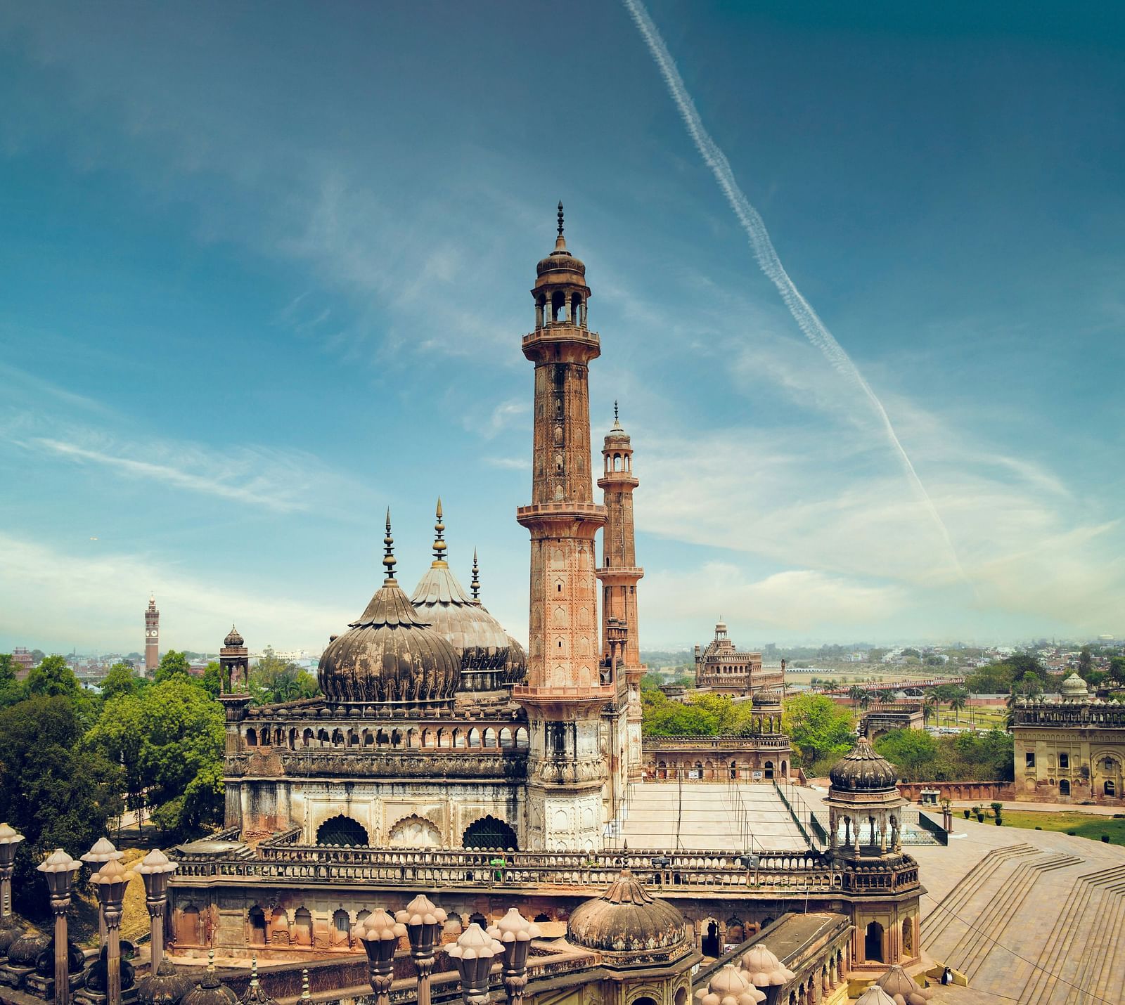 A wide view featuring a tower and domed structures under a bright sky