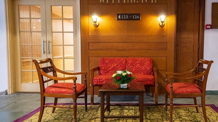 Two chairs and a sofa along with a table at Wellington Conference Hall in Kodaikanal