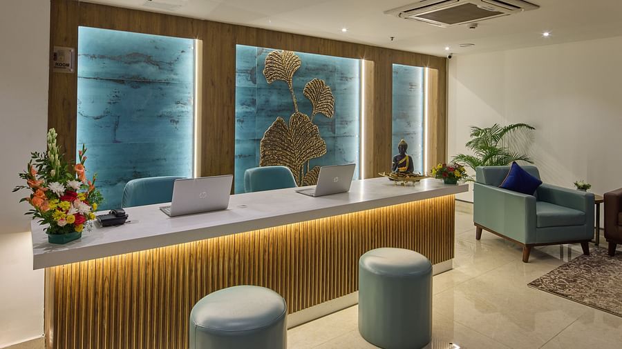A reception desk with a welcoming seating area and floral decorations - Grand Continent, Brookefield