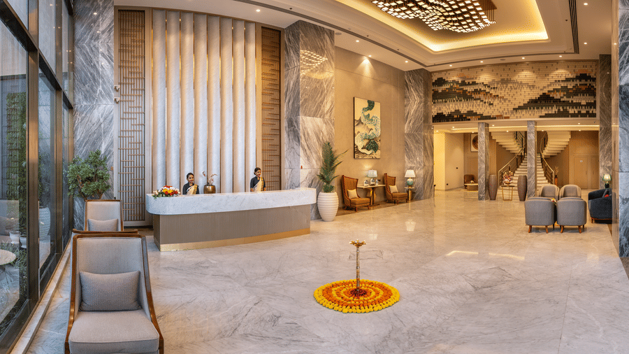 Lobby with cozy seating chairs, a round coffee table, and a striking ceiling design at Lords Inn Somnath, offering a warm welcome.