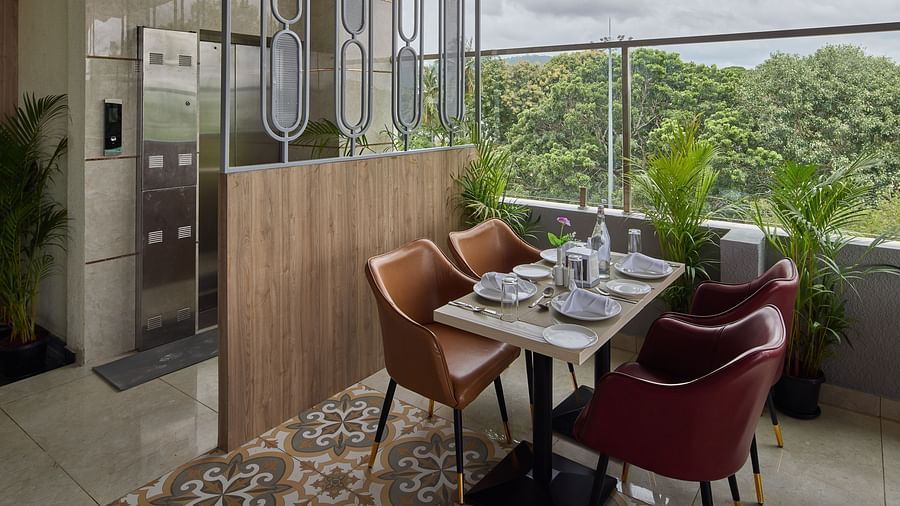 A corner table with comfortable chairs in our restaurant in Mysore