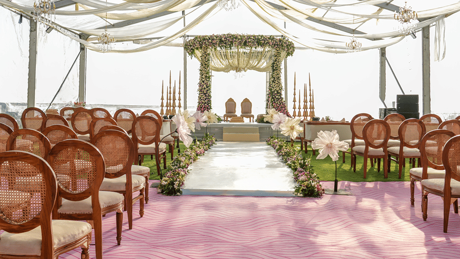 Rows of wooden chairs facing a central aisle leading toward a decorated wedding mandap setup at Ramada by Wyndham Mussoorie Mall Road.