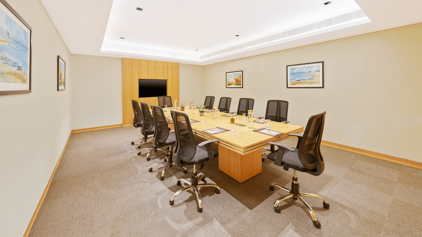 An overview of Waves Meeting Room with a table and many chairs in view | The Resort, Mumbai.