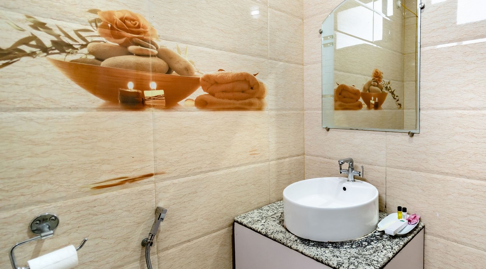 A mirror hung on decorative tiled walls above a sink at Flutter Hotels and Resorts, Lansdowne.