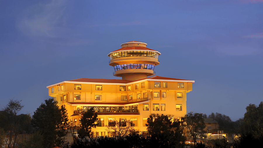 Facade at RS Sarovar Portico, Palampur Resorts, with night sky in the backdrop.