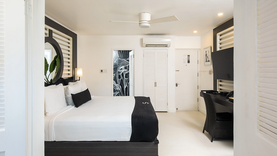 A hotel room in Jamaica with a large bed and a ceiling fan - S Hotel Montego Bay, Jamaica