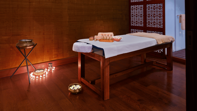 A massage table in our spa room with various treatment products - The Resort, Mumbai.