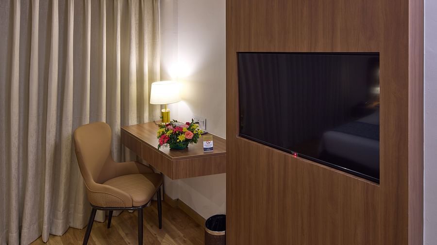 A room with a large window, wall-mounted TV, and wooden accents - Grand Continent, Brookefield