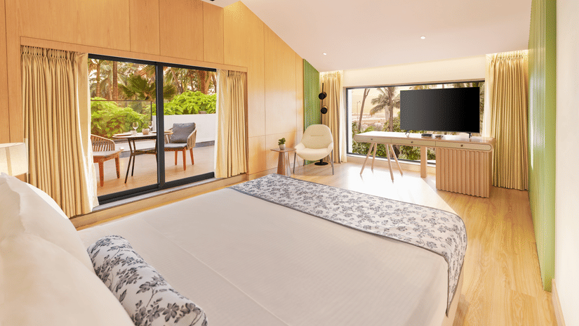 Bay View Living Room featuring a king size bed, a patio, and a wall-mounted television | The Resort, Mumbai