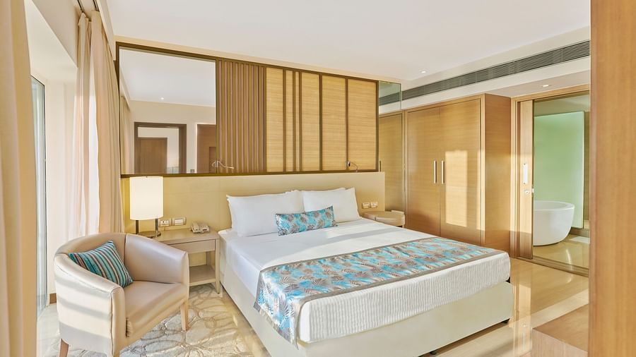 A bed and  a chair in a bedroom | The Resort