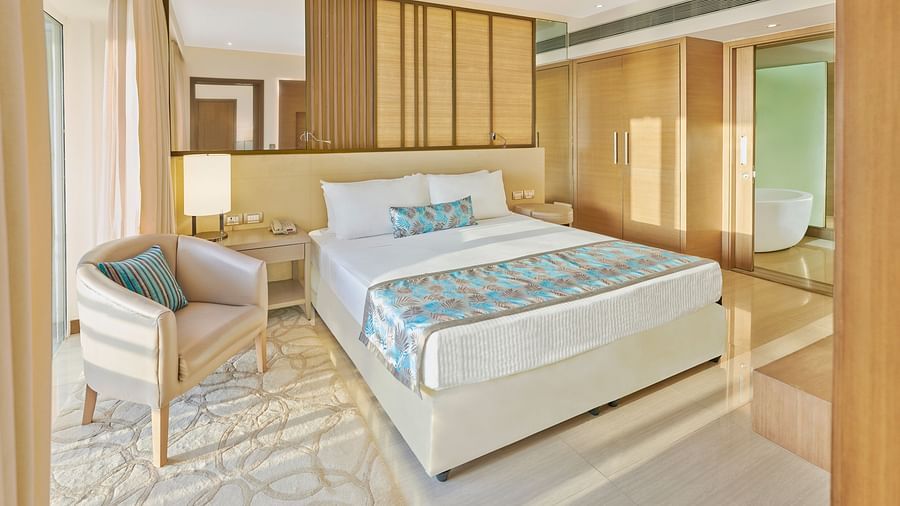 A bed and  a chair in a bedroom | The Resort