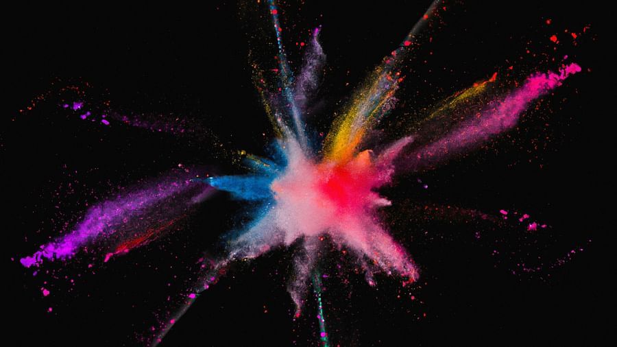 A colourful explosion of powder paint on a black background.