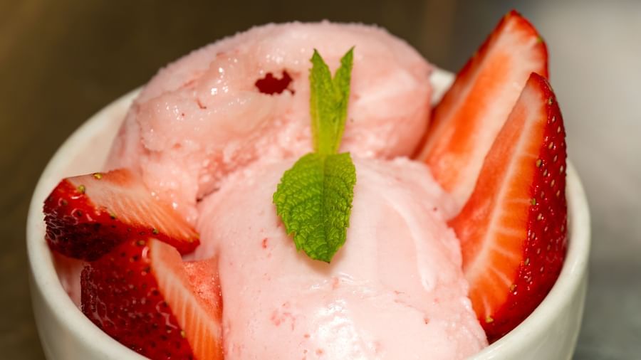 Bowl of strawberry ice cream topped with fresh strawberries and a mint leaf served as dessert at Narrow Gauge Inn.