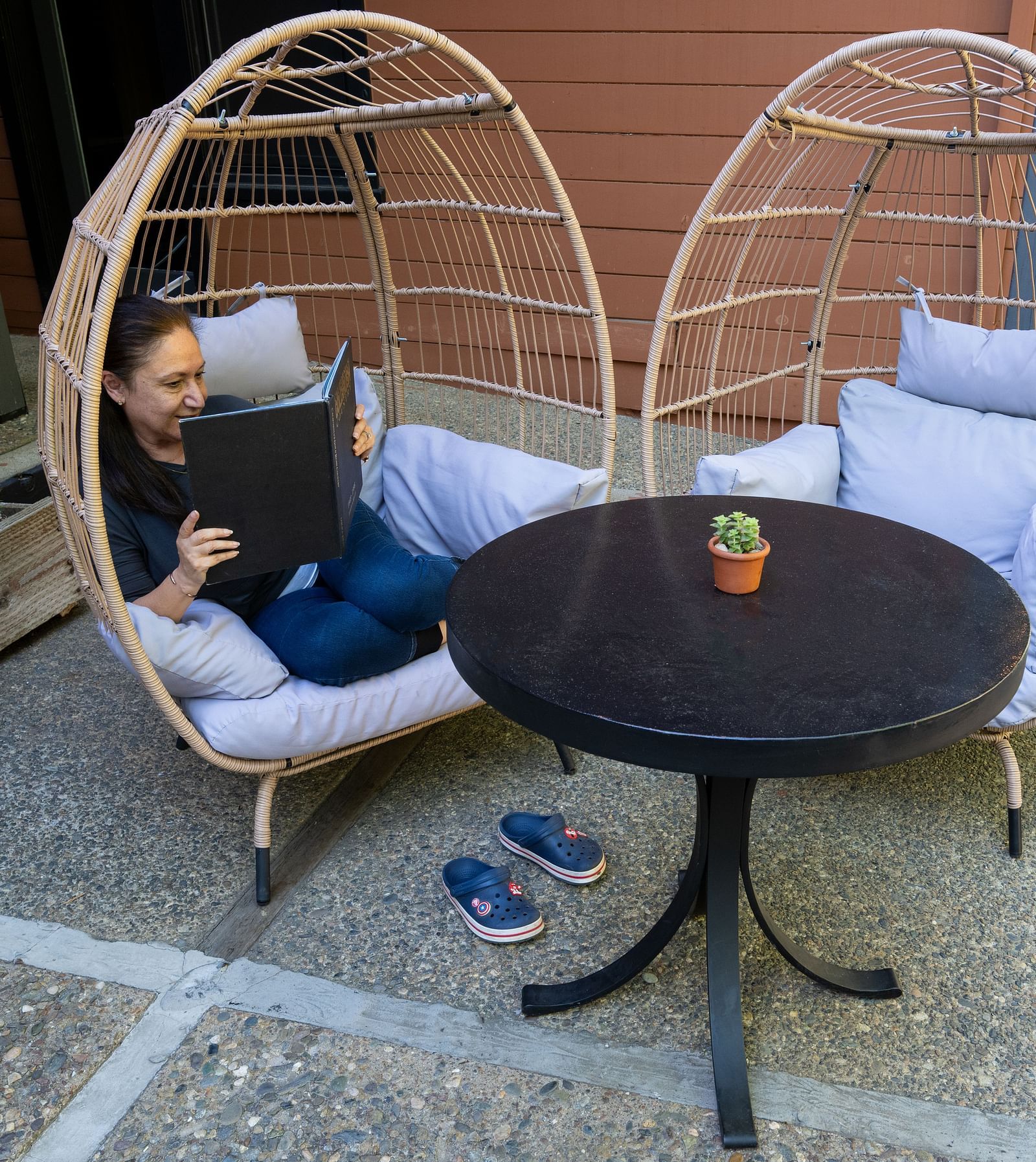 Outdoor seating with rattan chairs and drinks on a patio area at The Groveland Hotel.