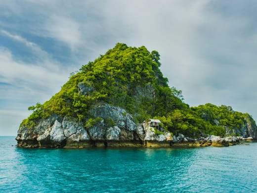 A forested island rising from turquoise water in the Andamans