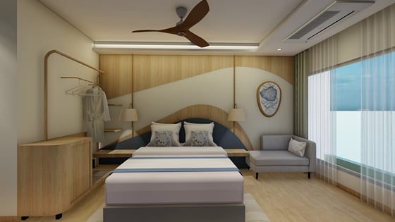 Sea View Room bed made up with cushions beside a curtained window | Shirgaonkar Beach Resort