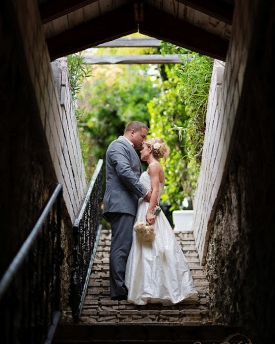 A couple embracing on the garden stairs at A Stone's Throw Away