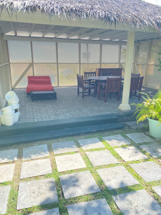 The thatched cabana seating area beside the garden at A Stone's Throw Away