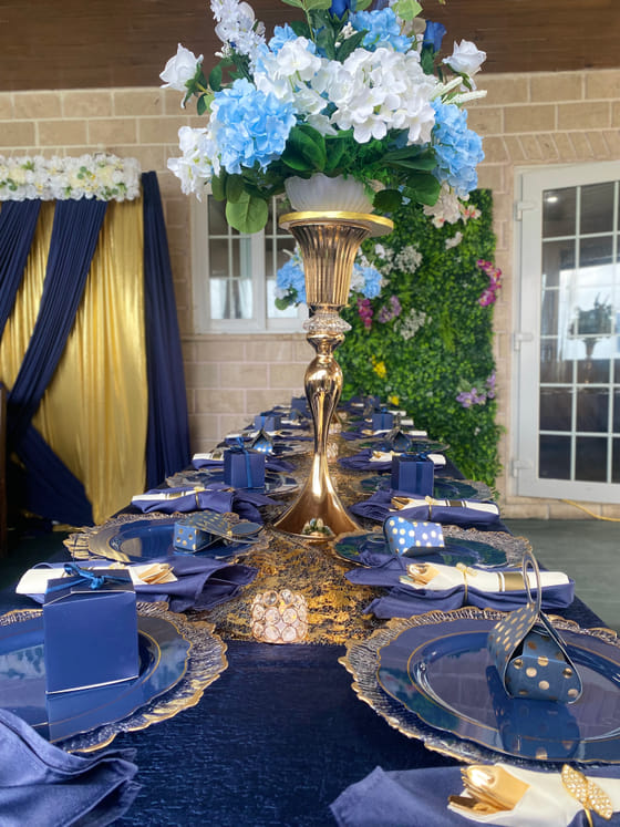 A long banquet table styled in navy and gold at A Stone's Throw Away