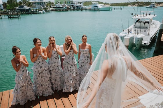 Bride and bridesmaids sharing a first look by the water at Abaco Inn