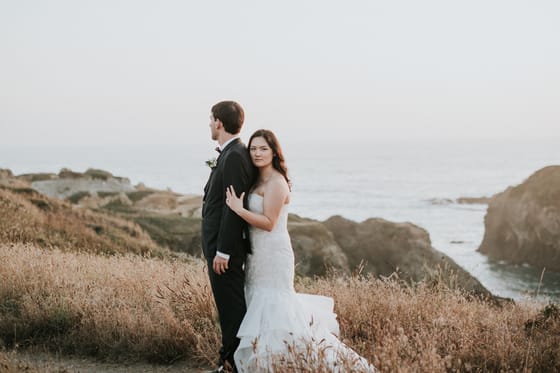 A couple on a grassy hill above Mendocino Bay