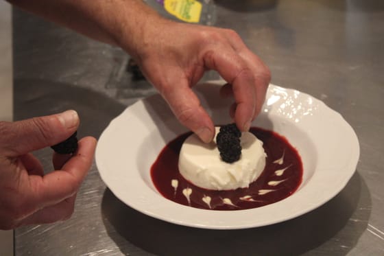 A chef finishing a panna cotta dessert at Hartstone Inn