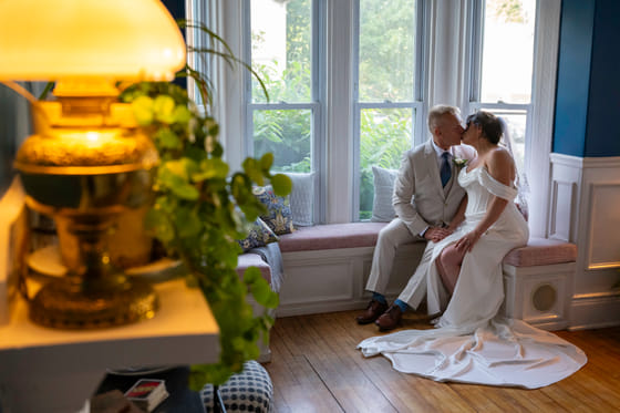 A couple on the window seat in the front lounge at Hartstone Inn