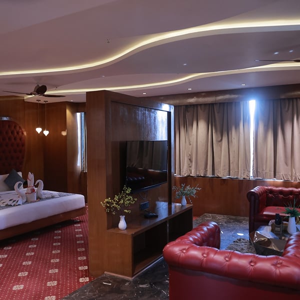 Sky Suite bedroom with a king bed, lounge seating and cove lighting at Skyline Resort & Convention Centre