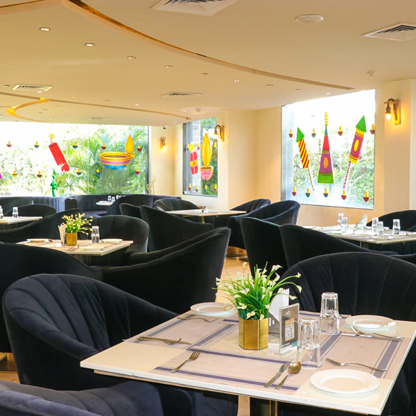Marble tables and navy velvet chairs in the Zeus fine-dining restaurant at Skyline Resort & Convention Centre