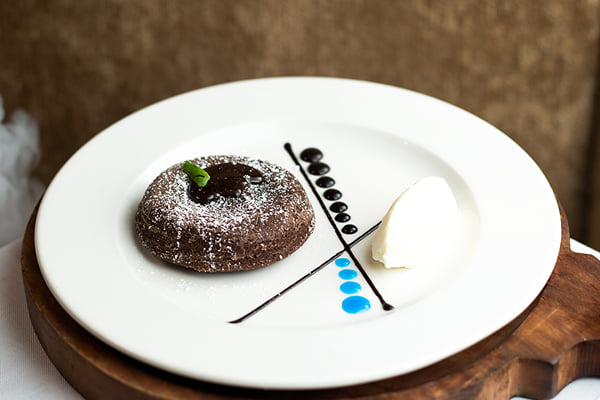 Food: chocolate lava cake with ice cream and sauce dots on a plate