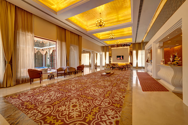 Lobby: spacious lobby with red patterned carpet, gold ceiling, curtains and reception counter at right