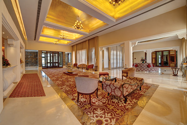 Lobby: lobby view toward glass entrance doors with patterned carpet, sofas and chandeliers