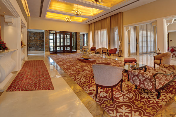 Lobby: lobby with carpeted floor, sofas, entrance doors and lit ceiling panels