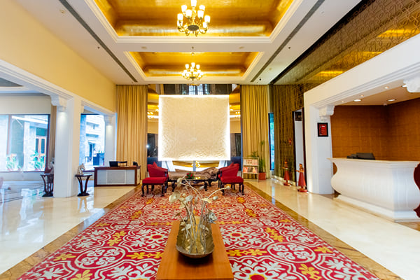 Lobby: lobby with patterned red carpet, lotus sculpture, red chairs and reception counter at right