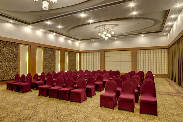 Meridian hall: banquet hall with rows of maroon chairs in theatre-style layout and chandelier