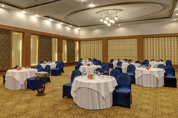 Meridian hall: banquet hall set with round white-clothed tables and navy chair covers