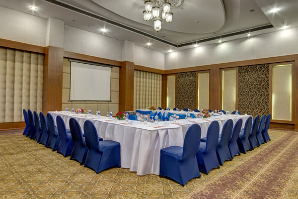 Meridian hall: banquet hall with U-shaped table setup, navy chairs and projection screen
