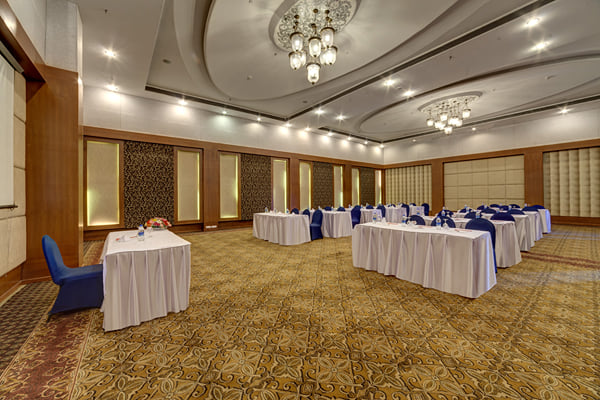 Meridian hall: banquet hall with long white-clothed tables and navy chairs in classroom layout
