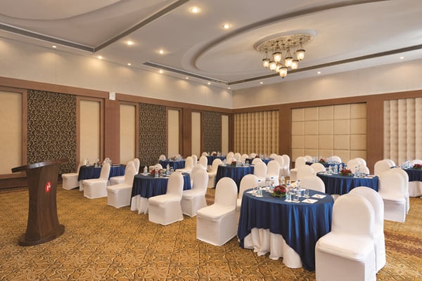 Meridian hall: banquet hall with round navy-cloth tables, white chair covers and lectern at left