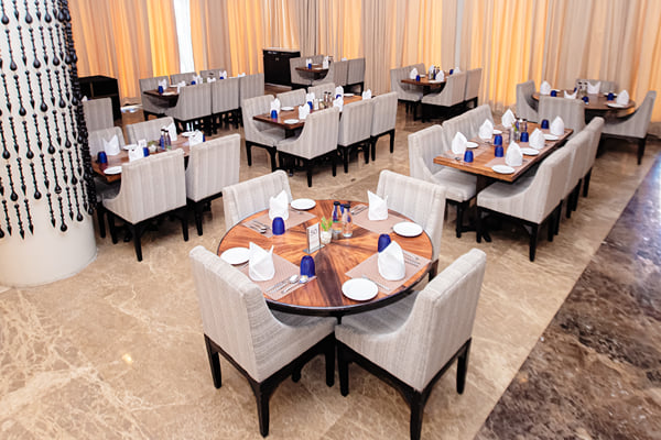 Myra restaurant: round table with chairs in restaurant near a beaded pillar and curtains