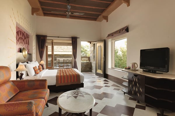 Premium Room: guest room with bed, orange sofa, television and patterned tile floor