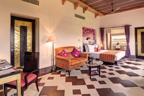Premium Room: closer view of guest room with orange sofa, bed, desk and patterned floor