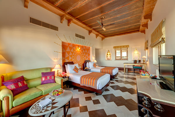 Premium Room: twin beds, green sofa and coffee table in a guest room with wooden ceiling