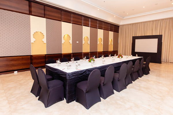 Zuma hall: meeting room with long table, black chair covers, panelled wall and projection screen